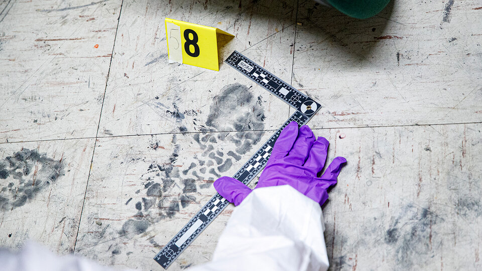 Forensic Biologist places a microcentrifuge tube into a holder